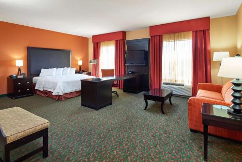 a hotel room with a bed and a desk and chairs at Hampton Inn & Suites Waco-South in Waco