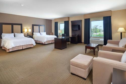 a hotel room with two beds and a couch at Hampton Inn & Suites Decatur in Decatur