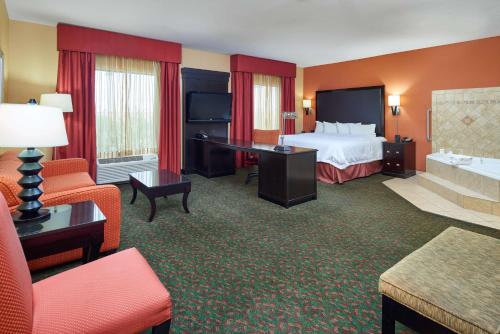 a hotel room with a bed and a living room at Hampton Inn & Suites Waco-South in Waco