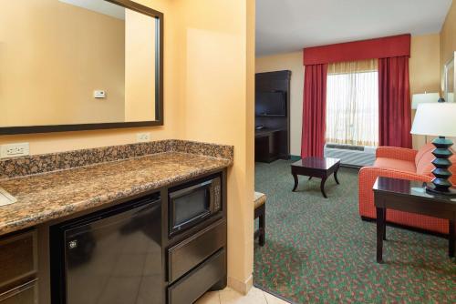 a hotel room with a large mirror and a living room at Hampton Inn & Suites Waco-South in Waco