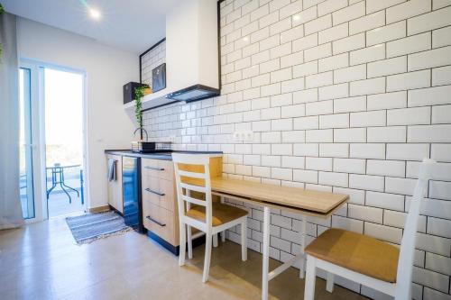 a kitchen with a wooden table and a wooden chair at Mousikorama Apartments in Faliraki