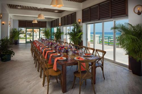 ein langes Esszimmer mit einem langen Tisch und dem Meer in der Unterkunft Hilton Daytona Beach Resort in Daytona Beach