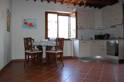 eine Küche mit einem Tisch und Stühlen sowie einem Tisch und einem Fenster in der Unterkunft Casa VALGRAZIOSA in Calci