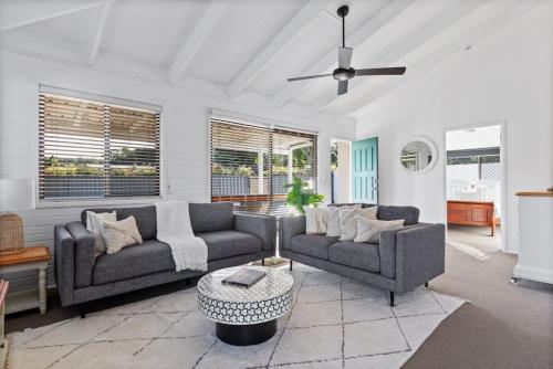 a living room with two couches and a ceiling fan at Pet friendly family escape in Coolum Beach
