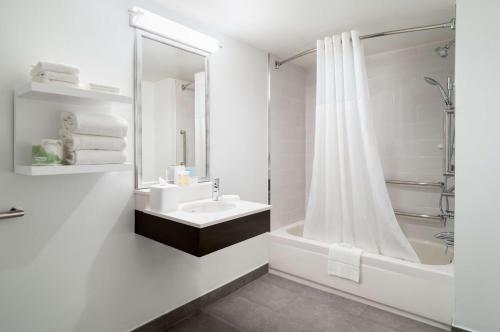 a white bathroom with a sink and a shower at Hampton Inn Philadelphia Center City-Convention Center in Philadelphia