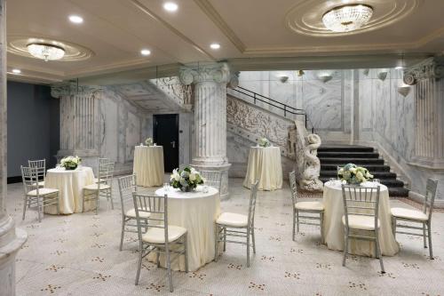 a banquet hall with tables and chairs with flowers on them at The Candler Hotel Atlanta, Curio Collection by Hilton in Atlanta