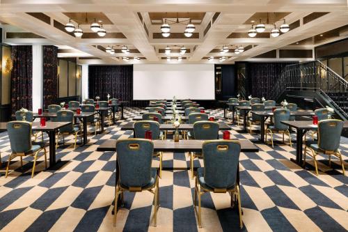 a large room with tables and chairs and a projection screen at The Candler Hotel Atlanta, Curio Collection by Hilton in Atlanta
