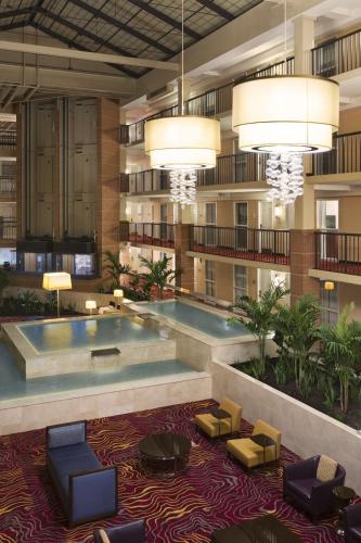 a hotel lobby with a large pool and chairs and lights at Embassy Suites Cleveland - Beachwood in Beachwood