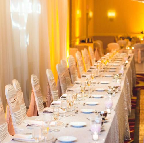 a long table with white plates and glasses on it at Embassy Suites Cleveland - Beachwood in Beachwood