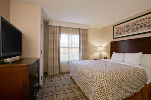 a hotel room with a bed and a flat screen tv at Embassy Suites Cleveland - Beachwood in Beachwood