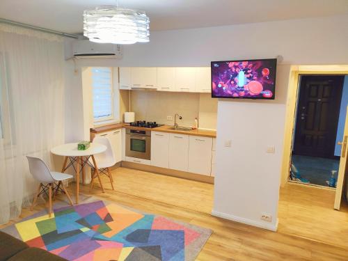 una cucina con tavolo e TV a parete di Baneasa Apartment Residence a Bucarest