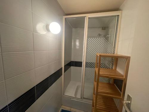 een douche met een glazen deur in de badkamer bij Chambre atypique in Saint-Blaise