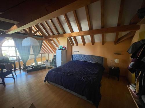 a bedroom with a bed in a room with wooden ceilings at Chambre atypique in Saint-Blaise