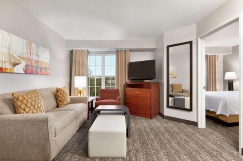 a living room with a couch and a bed and a television at Homewood Suites by Hilton Columbus-Dublin in Dublin