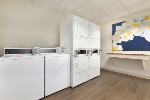 a kitchen with white appliances and a painting on the wall at Homewood Suites by Hilton Columbus-Dublin in Dublin