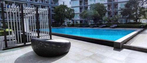 a black chair sitting in front of a swimming pool at Vacation pool condo in Ban Rangeng