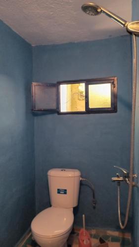 y baño con aseo, ventana y ducha. en Dar Panorama Chefchaouen, en Chefchaouen