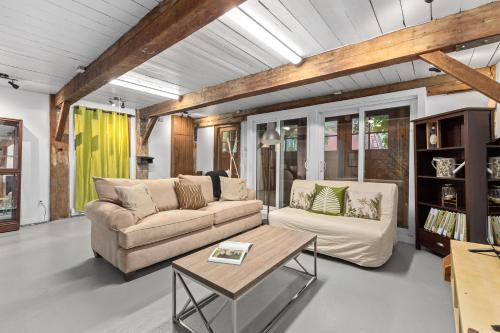 a living room with two couches and a coffee table at L'Artisan - Vieux-Terrebonne in Terrebonne