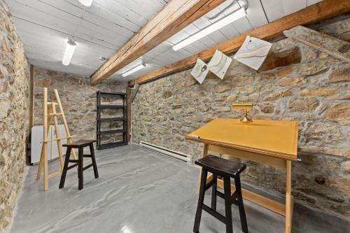 a room with a wooden table and two stools at L'Artisan - Vieux-Terrebonne in Terrebonne