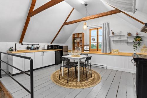 a kitchen with a table and chairs in a room at L'Artisan - Vieux-Terrebonne in Terrebonne