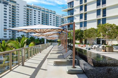 a patio with an umbrella and tables and chairs at The Gates Hotel South Beach in Miami Beach