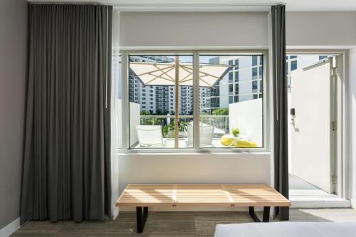 a room with a window with a bench in front of it at The Gates Hotel South Beach in Miami Beach