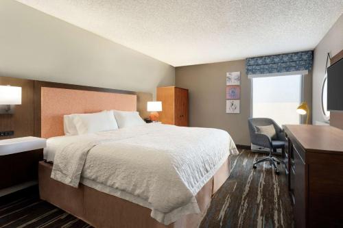錢德勒的住宿－鳳凰城錢德勒漢普頓酒店，酒店客房设有一张大床和一张书桌。