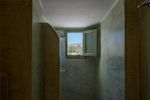 a bathroom with a window and a walk in shower at Ambeli Apartments in Perivolos