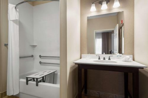 uma casa de banho com um lavatório e um espelho em Homewood Suites Rochester-Henrietta em Henrietta