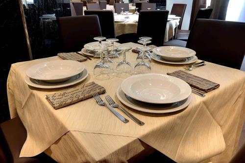 a table with plates and wine glasses on it at Hotel Park in Castiglion Fiorentino