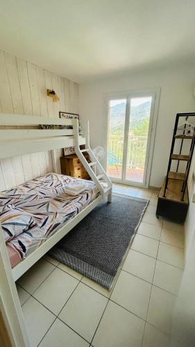 a bedroom with a bunk bed and a large window at Sur les hauteurs de Collioure in Collioure