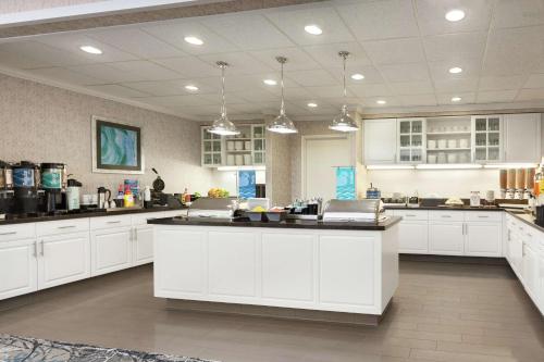 a large kitchen with white cabinets and a large island at Homewood Suites by Hilton Sacramento/Roseville in Roseville