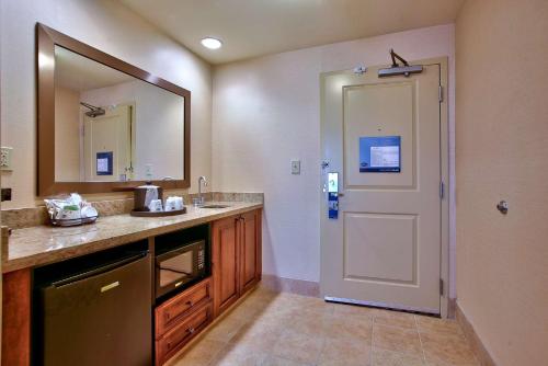 a bathroom with a sink and a mirror and a door at Hampton Inn & Suites Scottsdale at Talking Stick in Scottsdale
