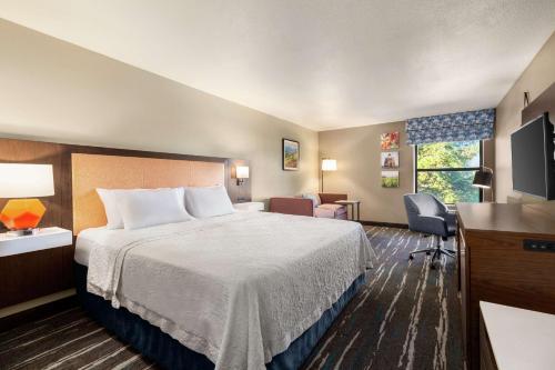 a hotel room with a bed and a desk at Hampton Inn Tracy in Tracy