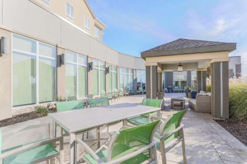 a patio with a table and chairs in front of a building at Hilton Garden Inn Ardmore in Ardmore