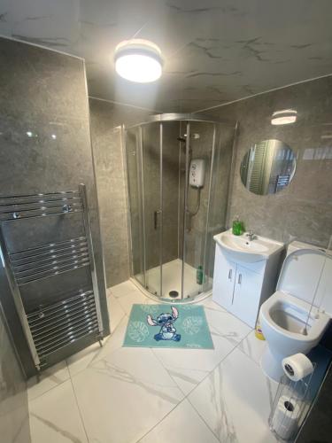 uma casa de banho com um chuveiro, um WC e um lavatório. em Luxury Fully Furnished Bedroom em Leicester