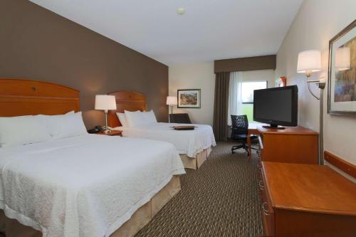 a hotel room with two beds and a flat screen tv at Hampton Inn Decatur/Forsyth in Forsyth