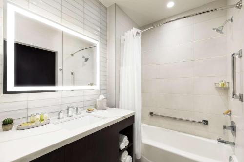 a bathroom with a sink and a tub and a mirror at Doubletree By Hilton Tucson Downtown Convention Center in Tucson