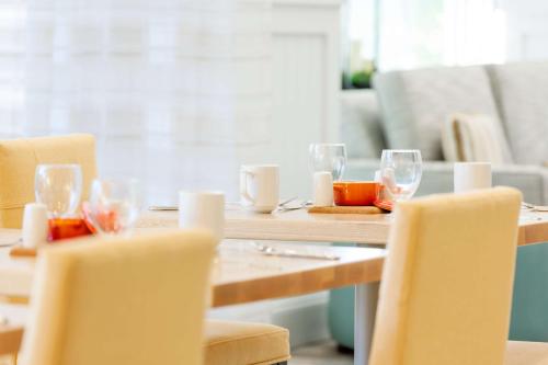 a wooden table with chairs and wine glasses at Hilton Garden Inn Key West / The Keys Collection in Key West