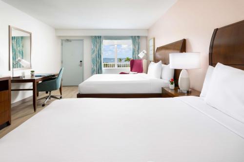 a hotel room with two beds and a desk at Hilton Garden Inn Key West / The Keys Collection in Key West