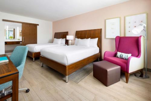 a hotel room with two beds and a pink chair at Hilton Garden Inn Key West / The Keys Collection in Key West