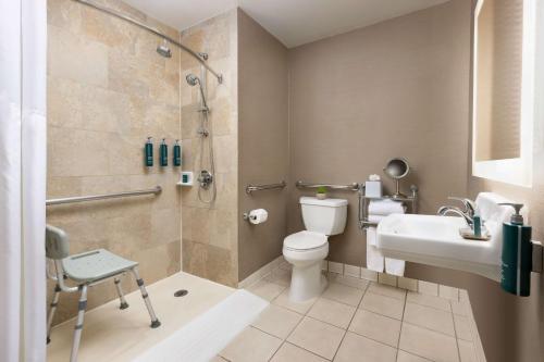 a bathroom with a shower and a toilet and a sink at Hilton Tucson East in Tucson