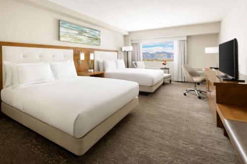 a hotel room with two beds and a flat screen tv at Hilton Tucson East in Tucson