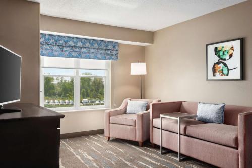 a living room with a couch and a chair and a window at Hampton Inn & Suites Fort Wayne-North in Fort Wayne