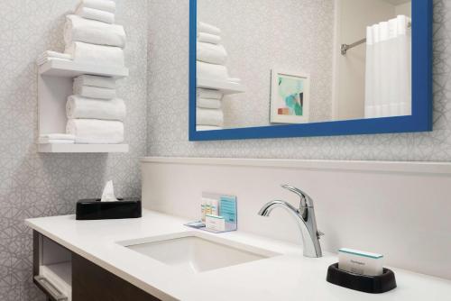 a bathroom with a sink and a mirror and towels at Hampton Inn & Suites Fort Wayne-North in Fort Wayne