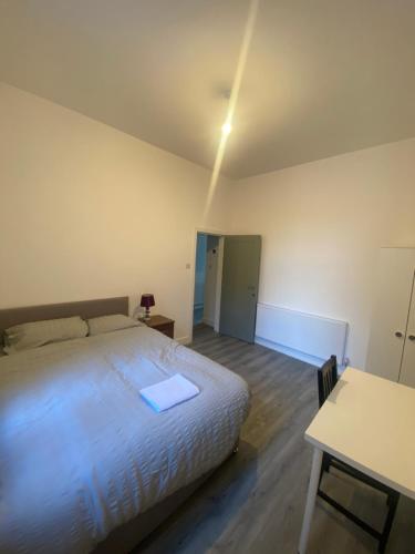 a bedroom with a large white bed and a table at Luxury Fully Furnished Bedroom in Leicester