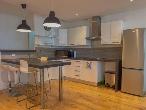 a kitchen with a table and chairs and a refrigerator at Superbe Appartement au bord de la Garonne Toulouse in Toulouse
