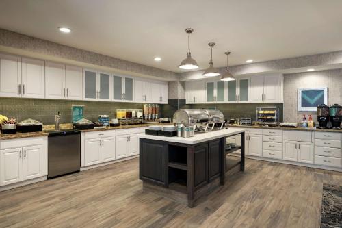 a large kitchen with white cabinets and a large island at Homewood Suites by Hilton Erie in Erie