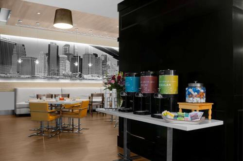 a restaurant with a table with wine bottles on it at Hilton Garden Inn New York - Times Square Central in New York