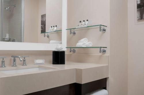 W łazience znajduje się umywalka i lustro. w obiekcie Hilton Garden Inn New York - Times Square Central w Nowym Jorku